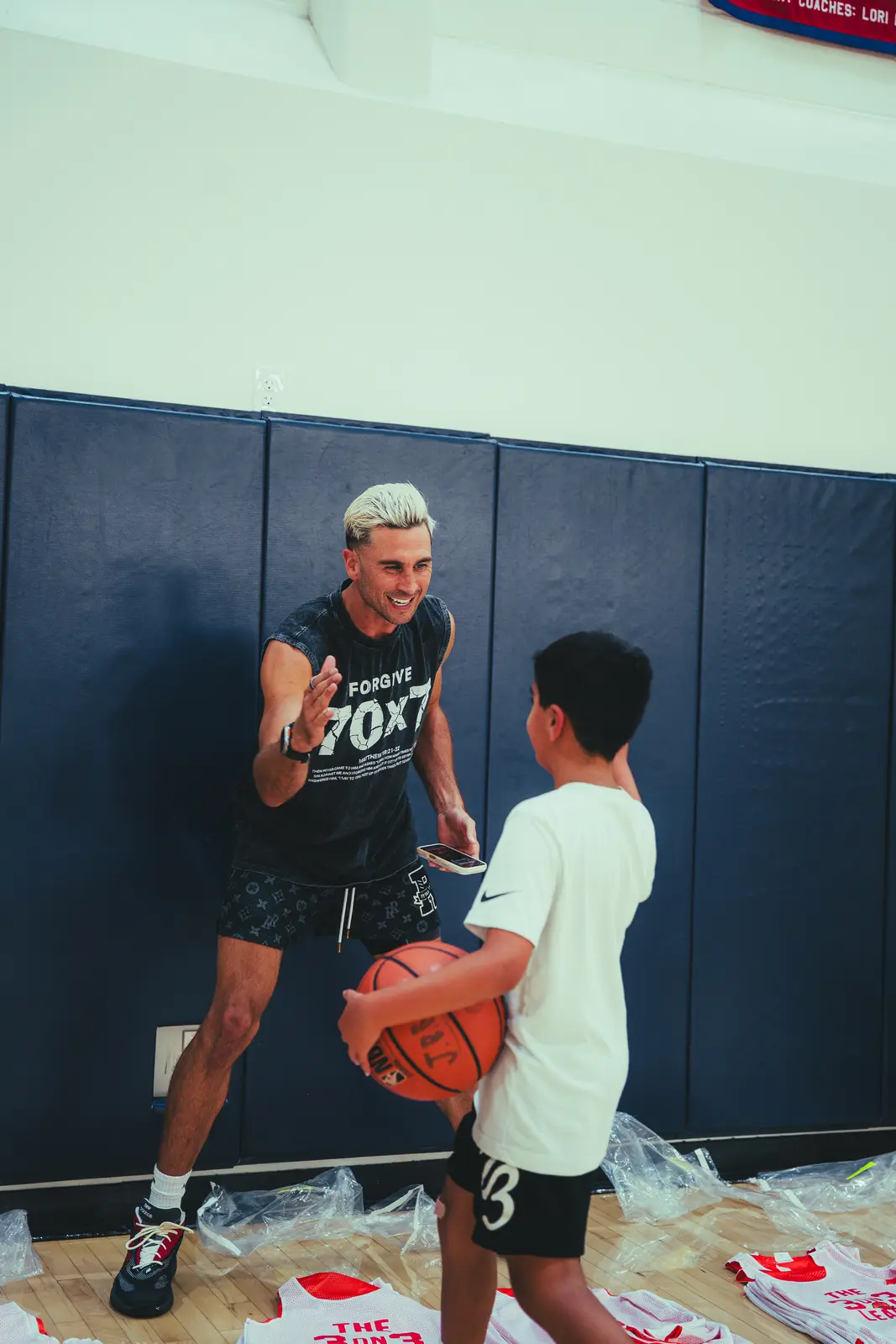Jordan Lawley high-fiving a young player at Boombase.