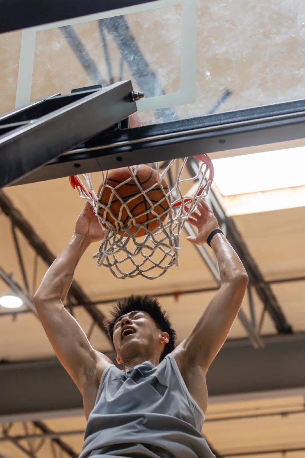 Finishing a two-handed dunk at the rim.